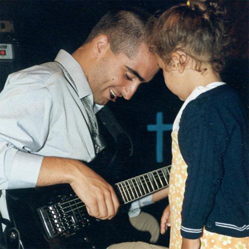 Miguel Gigante playing while a child looks curioulsy